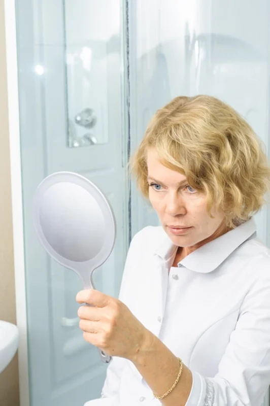 Kobieta w średnim wieku w białej koszuli