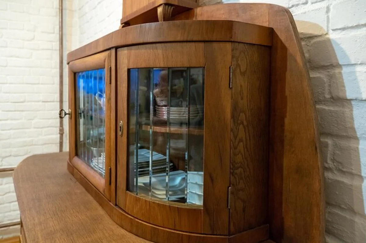 Stary drewniany kredens na tle białej ceglanej ściany