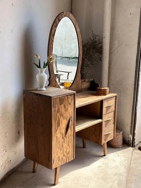 Zabytkowa drewniana toaletka z lustrem i wazonem z kwiatami