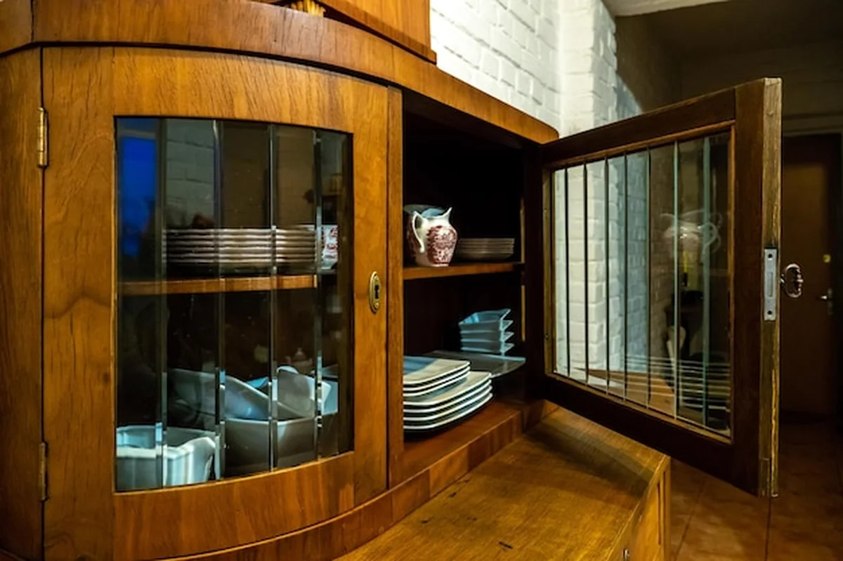 Stary drewniany kredens na tle białej ceglanej ściany