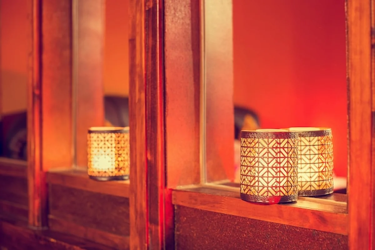 Orientalne świeczki na drewnie z kolorowym arabskim wzorem w tle