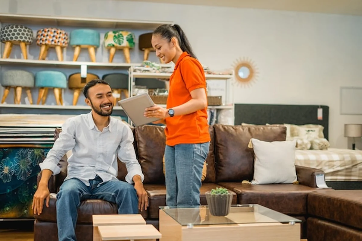 Klient płci męskiej patrzy na tablet w dziale meblowym