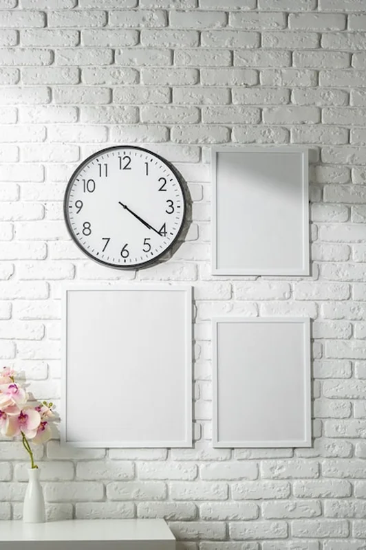Minimalistyczny biały dekor ściany z zegarem i ramkami fotograficznymi