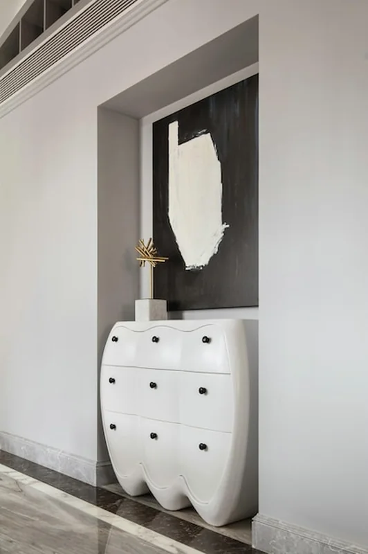 Nowoczesny biały kominek z abstrakcyjną sztuką