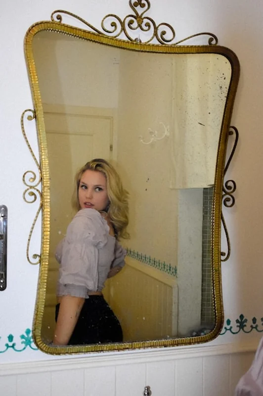 Młoda kobieta patrząca w lustro w domu