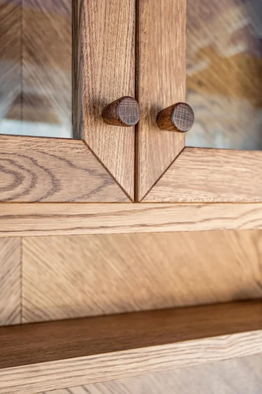 Eleganckie dębowe szafki z szklanymi drzwiami i drewnianymi guzikami z bliska