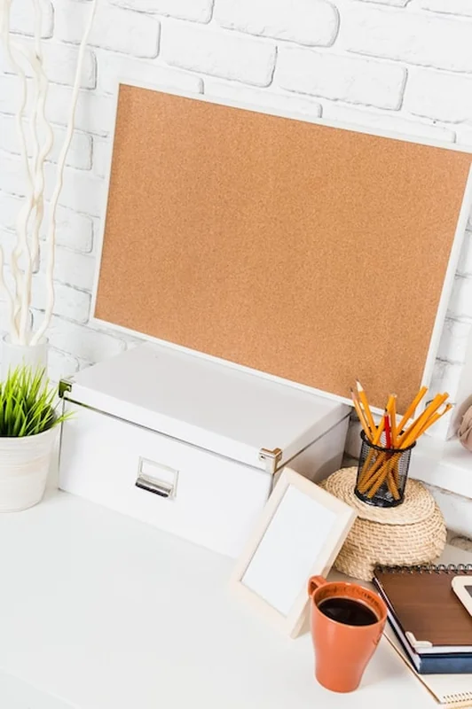 Przestrzeń robocza z deską korkową i narzędziami organizacyjnymi w jasnym, nowoczesnym otoczeniu