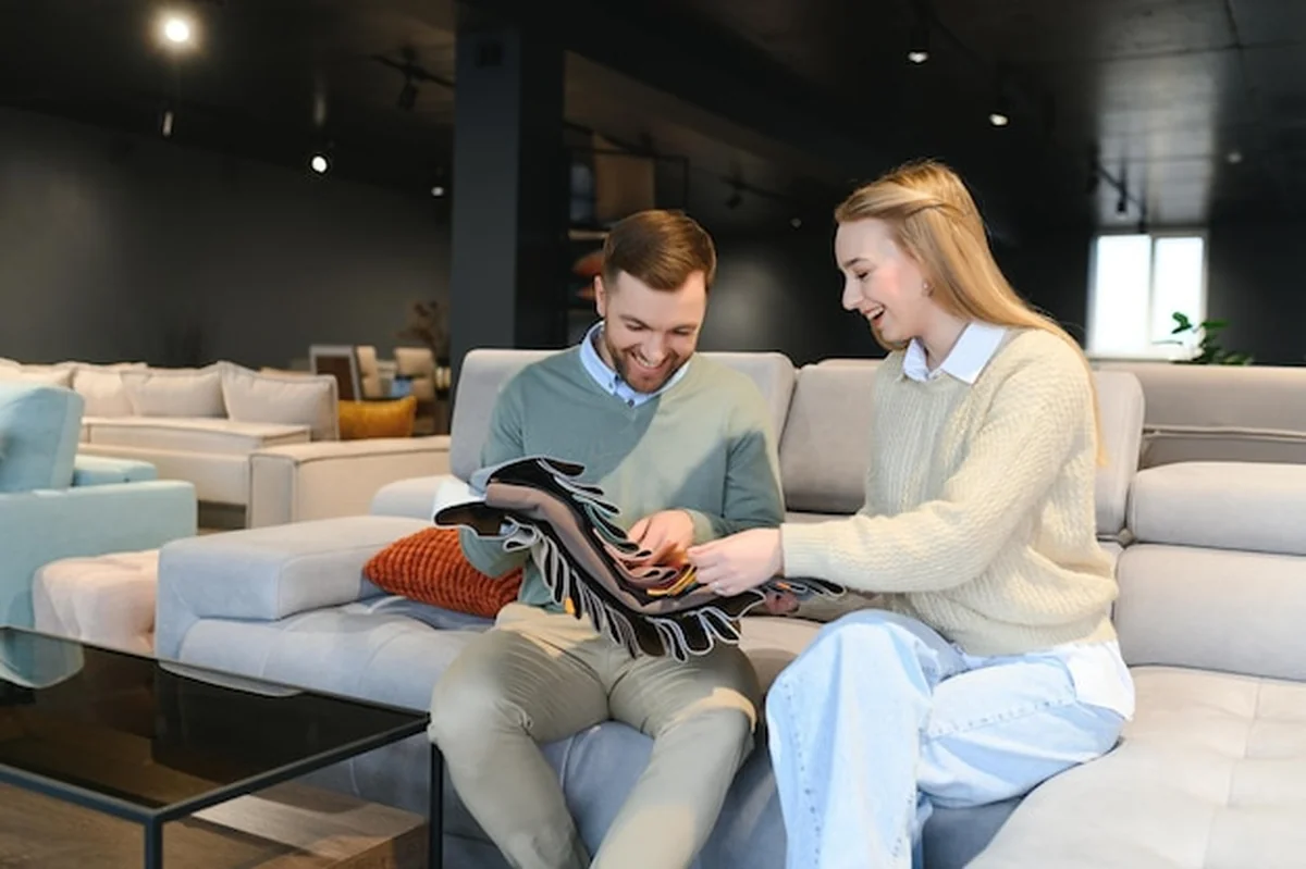 Para wybierająca kanapę i poduszki w sklepie z meblami