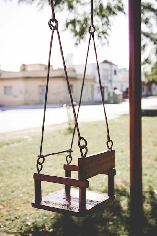 Pusta huśtawka na placu zabaw w parku sąsiedztwa