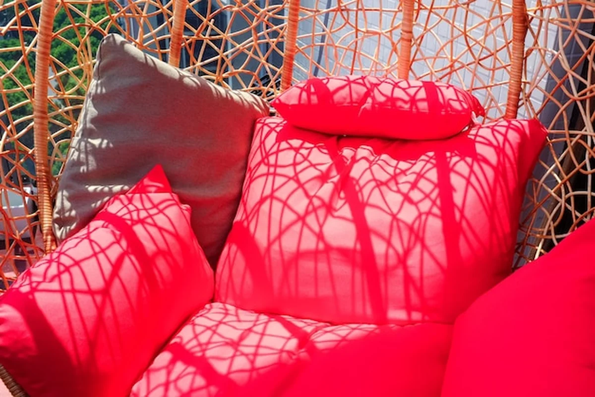 Zbliżenie czerwonych poduszek na huśtawkę ogrodową