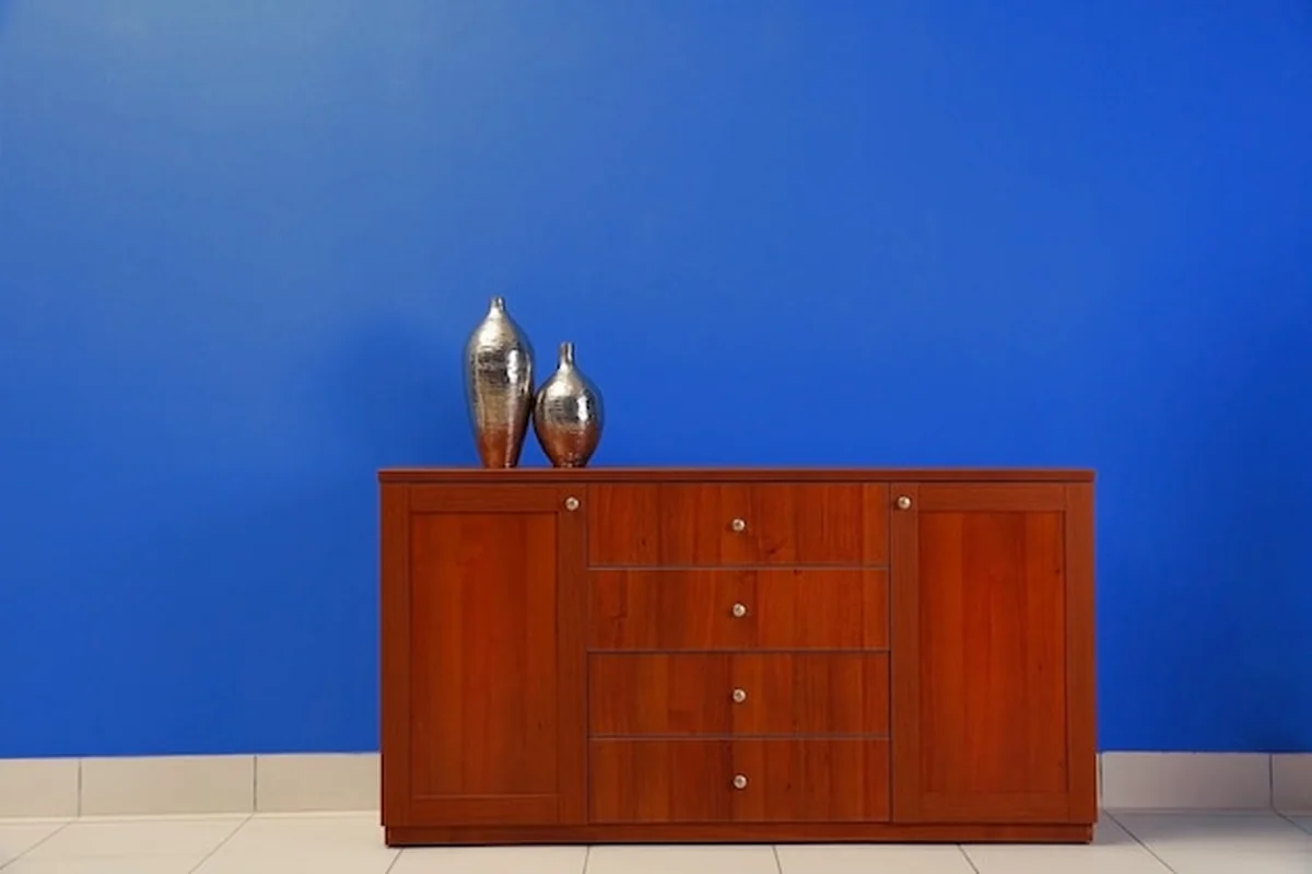 Drewniana komoda na niebieskim tle ściany