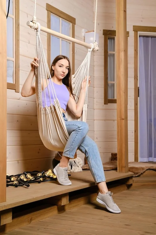 Wesoła kobieta w hamaku na wiejskim tarasie
