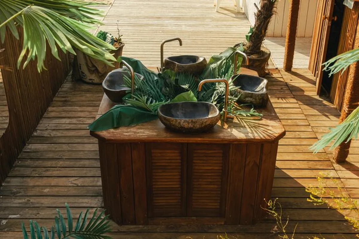 Tropikalne umywalki z liśćmi palmowymi i drewnianą podłogą