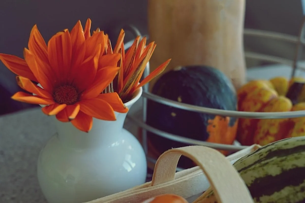 Pomarańczowy kwiat w wazonie na stole