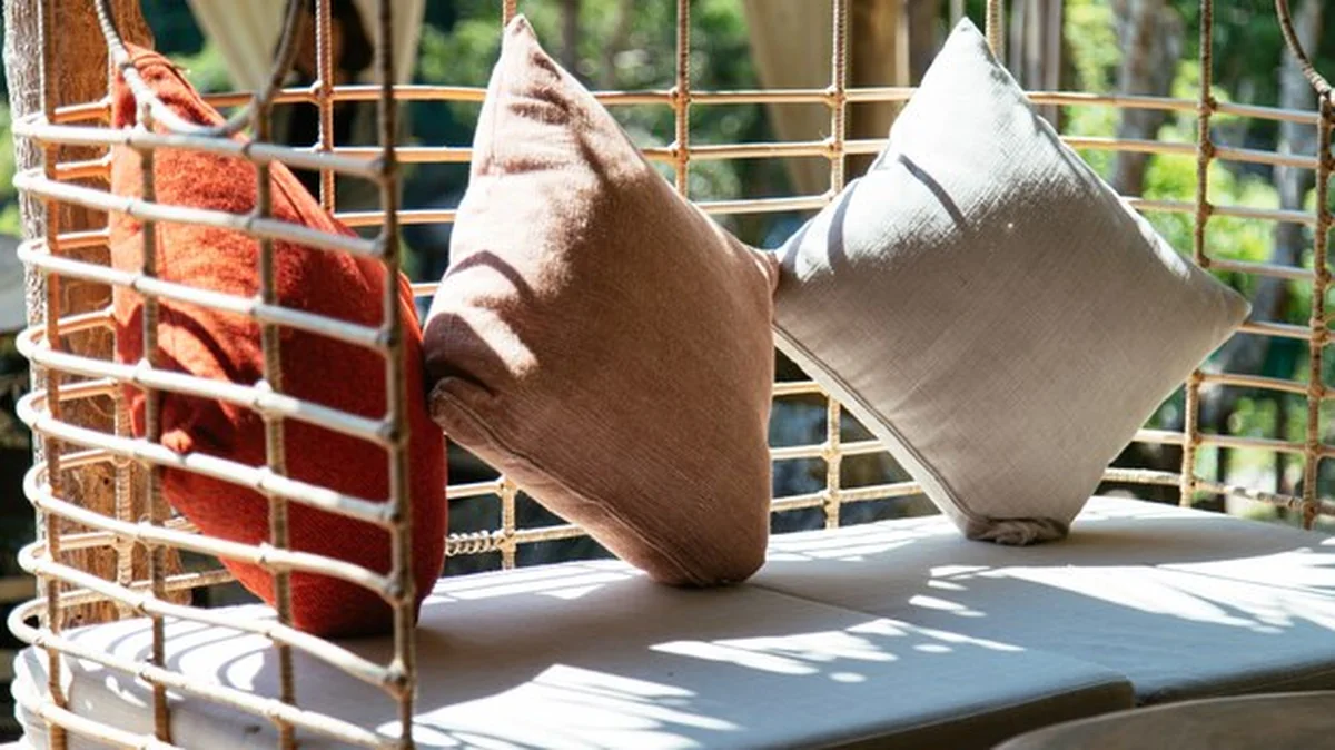 Trzy poduszki na krześle w promieniach słońca