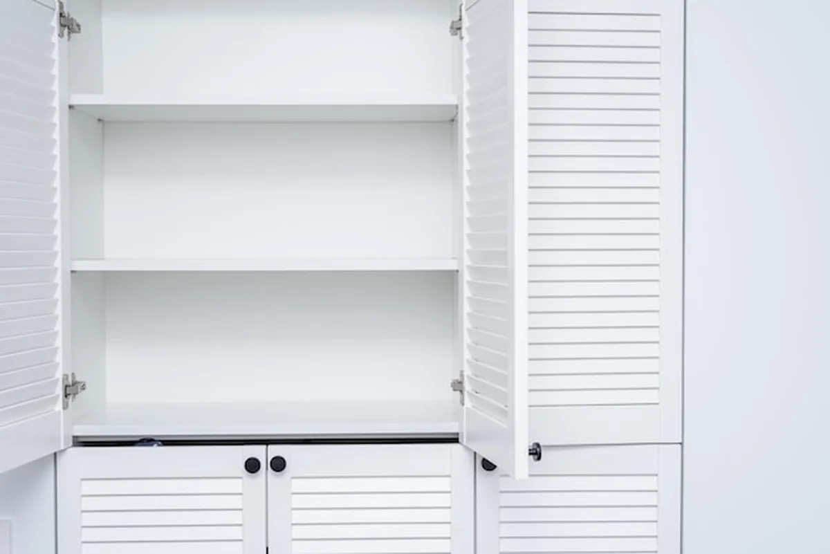 Puste półki białej szafy na ubrania