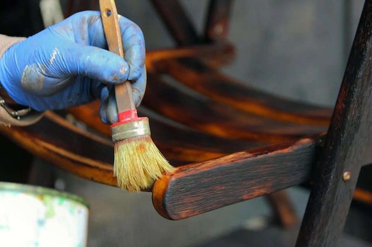 Ręka malująca drewno szczotką