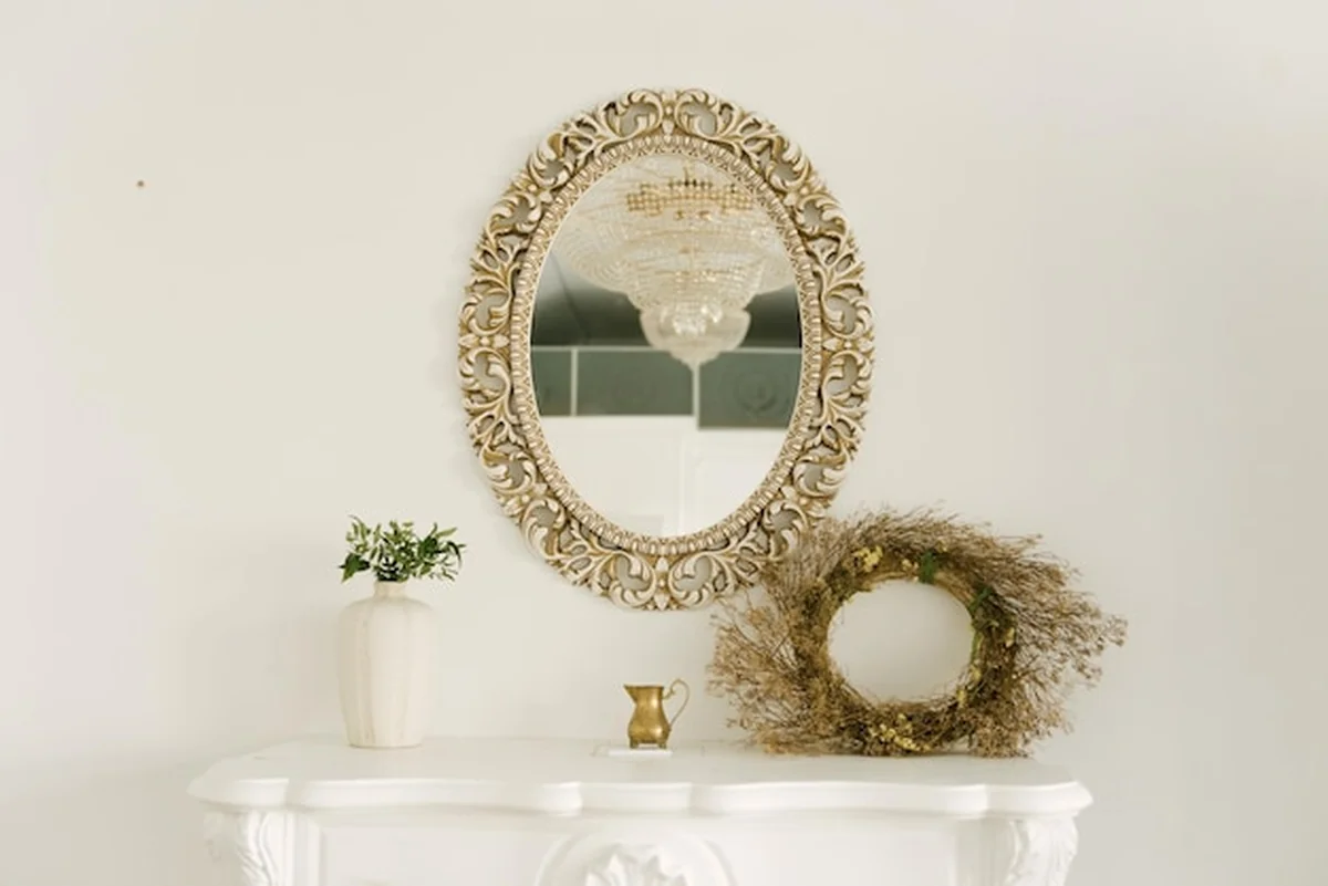 Vintage lustro na białym kominku i żyrandole w luksusowym wnętrzu