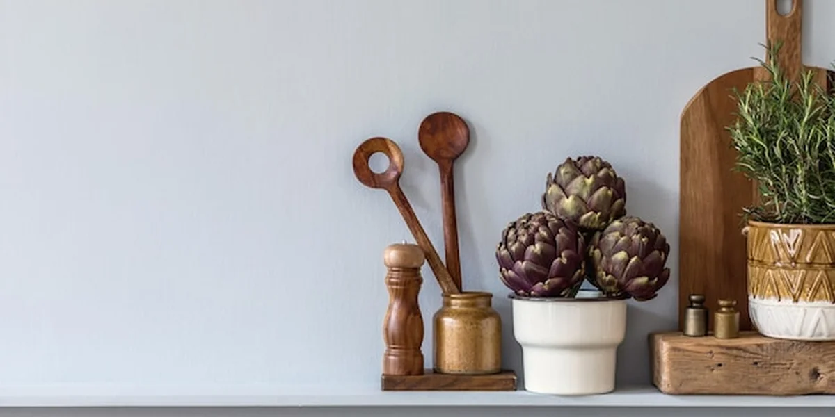 Nowoczesna kompozycja we wnętrzu kuchni z deską do krojenia warzyw, jedzeniem, ziołami, akcesoriami kuchennymi i półką